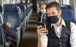 Voyageurs portant un masque dans une voiture de train presque vide